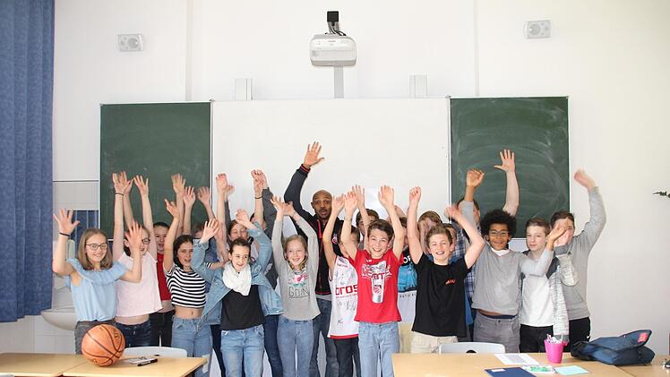 Die Jungen und M&auml;dchen der Klasse 7b des Gymnasium Casimirianum mit Basketballprofi "Ricky" Hickman.  Foto: Julian &Uuml;belhack
