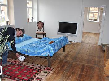 Wärmflasche und "Potschambä" (fränkisch für pot de chambre/Nachttopf) inklusive: Claus Schormann in einer der neuen Ferienwohnungen in der Specke, dem einstigen Haus der Gastwirtsfamilie Geuß. Doch der Nachttopf muss nicht verwendet werden. Stattdessen gibt es als weitere, ganz besondere Attraktion eine Außentoilette (überdacht und abgeschlossen).  Foto: Ralf Kestel