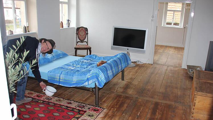 Wärmflasche und "Potschambä" (fränkisch für pot de chambre/Nachttopf) inklusive: Claus Schormann in einer der neuen Ferienwohnungen in der Specke, dem einstigen Haus der Gastwirtsfamilie Geuß. Doch der Nachttopf muss nicht verwendet werden. Stattdessen gibt es als weitere, ganz besondere Attraktion eine Außentoilette (überdacht und abgeschlossen).  Foto: Ralf Kestel