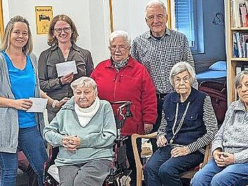 Norbert Lawatsch (hinten, r.), Elisabeth Ramming (Strickkreis, links daneben) Diana Pausch (Sozialstation, links daneben), Eva Seibold (Tagespflege, links daneben) sowie im Vordergrund G&auml;ste der Tagespflege bei der Spenden&uuml;bergabe.
