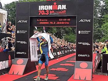 Andreas Dreitz aus Michelau gewinnt die 70.3-Premiere in Jönköping überlegen nach 3:49:45 Std. Schon mit Siegerkranz reißt er das Zielbanner nach oben.  Foto: pr