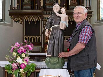 Bertram Becker zeigt die renovierte Figur des hl. Antonius in der Kirche in Burghausen. Foto: Björn Hein