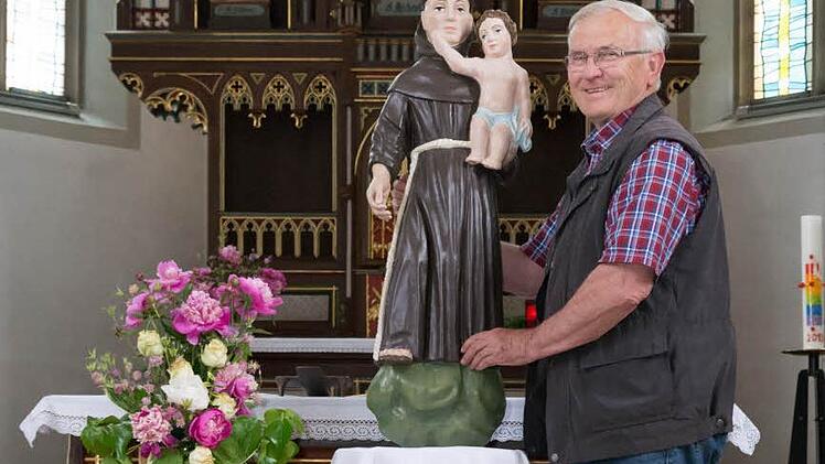 Bertram Becker zeigt die renovierte Figur des hl. Antonius in der Kirche in Burghausen. Foto: Björn Hein