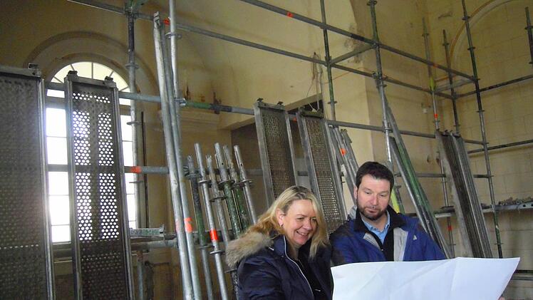 Andrea Schallenkammer und Projektleiter Torsten Storath stehen an der Stelle der ehemaligen Bühne. Im Hintergrund ist das Fenster, das bisher durch Bühne und Vorhänge verdeckt wurde. Foto: Julia Raab