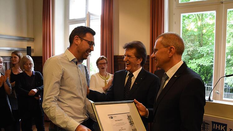 Matthias Wilz wird von Friedrich Herdan und Siegmar Schnabel die Urkunde überreicht.