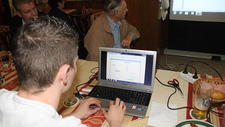 Matthias Schau bedient den Beamer, der die Wahlergebnisse auf die Leinwand projiziert.