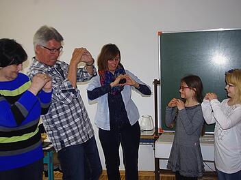 Theresia und Werner Krug sowie Christine Jandy üben mit Vivienne und Jule-Mai das Fingeralphabet ein.  Foto: Heike Schülein