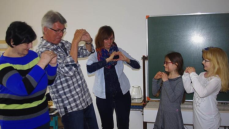 Theresia und Werner Krug sowie Christine Jandy üben mit Vivienne und Jule-Mai das Fingeralphabet ein.  Foto: Heike Schülein