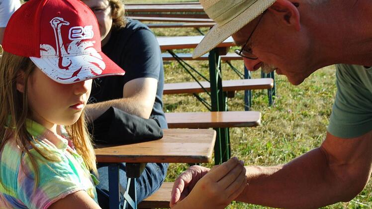 Sonja darf den bronzenen Grabschmuck, der hier am Staffelberg gefunden wurde, probieren.  Foto:  Franziska Wagner