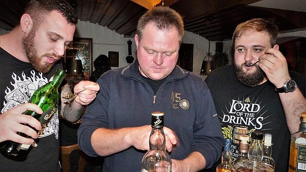 Andr&eacute; (links) und Tobias (rechts) aus Thurnau sowie Michael aus Stammbach testen eine Auswahl verschiedener Whiskys.  Fotos: Werner Rei&szlig;aus