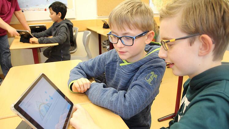 Die Fünftklässler Tim und Jarn  lösen verschiedene Matheaufgaben am Tablet.  Für richtige Lösungen erhalten sie Sterne und Smileys - gerne übertrumpfen sie sich gegenseitig und spornen sich dadurch an, auch in der Freizeit zum Tablet zu greifen, um Aufgaben zu lösen.Jutta Rudel