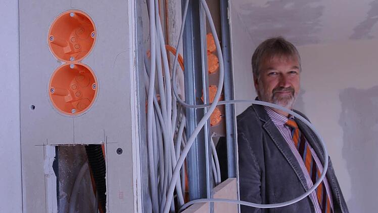 Stefan Kolck steht hinter der Medienleiste. Hier verbergen sich Elektrik, Medizintechnik, Telefon-, Schwesternruf- und Fernsehkabel.