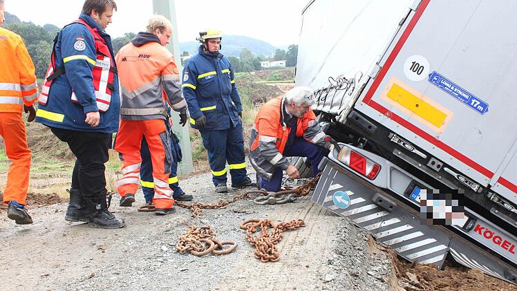 Mit Eisenketten versuchen die Helfer, den Lastwagen, der sich mittlerweile gefährlich geneigt hat, zu sichern. Foto: Katrin Geyer