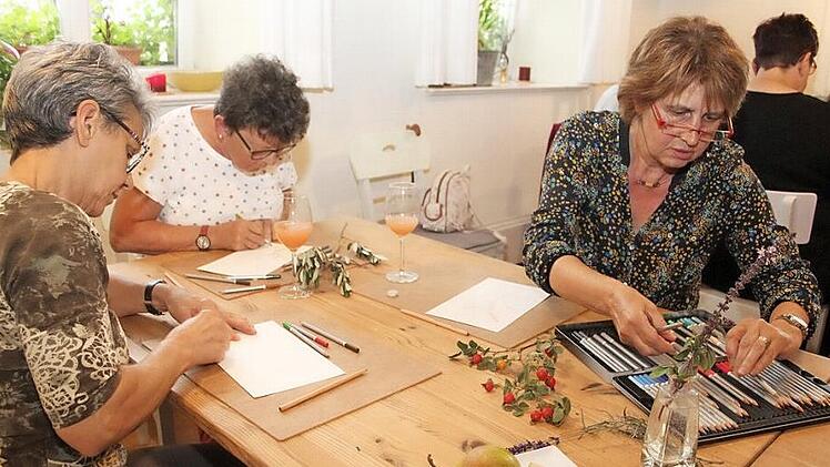 Ganz versunken versuchen Regina Stumpf, Margot Geier und Christine M&uuml;ller (von rechts nach links) den Olivenzweig, Hagebutten und bl&uuml;hendes Basilikum aufs Papier zu bringen. Fotos: Sonny Adam