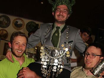 Maximilian Hofmann (links) und Michael Frankenberger tragen den neuen Schützenkönig Robert Ermisch durch das Schützenhaus. Foto: Sonny Adam