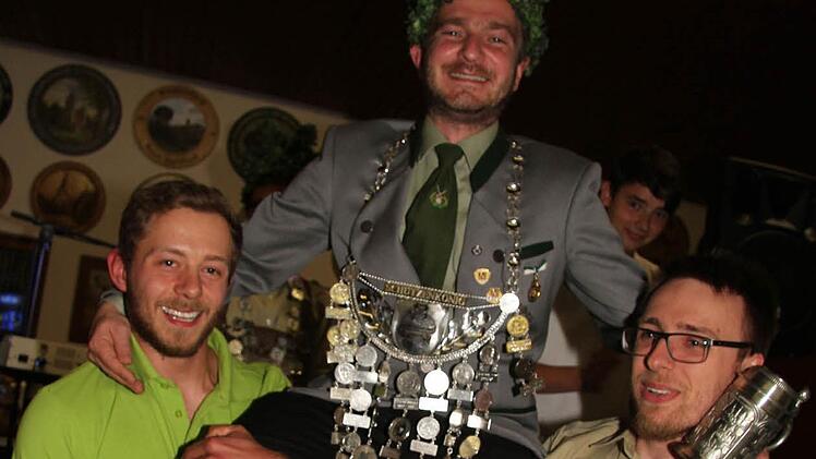 Maximilian Hofmann (links) und Michael Frankenberger tragen den neuen Schützenkönig Robert Ermisch durch das Schützenhaus. Foto: Sonny Adam