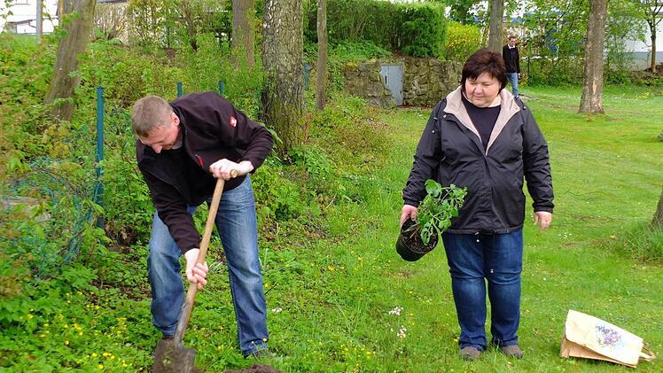 Walter Welsch und Silvia Jäger pflanzten den Hollerstrauch auf dem Vorbacher Spielplatz ein. Dabei beobachteten natürlich alle, ob sie es denn auch richtig machen. Foto: privat