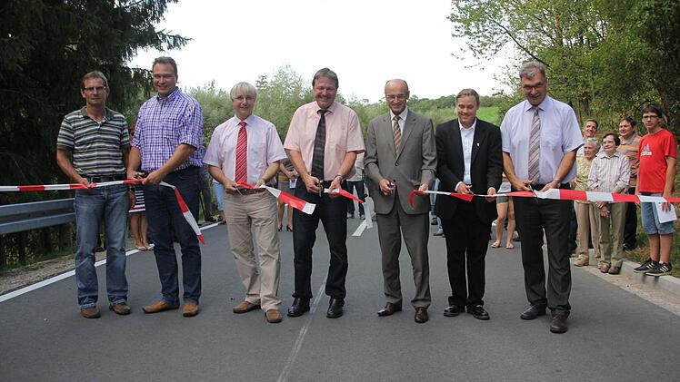 Sechs Scheren schnappten, als die Kreisstraße HAS 54 zwischen Unter- und Obermerzbach am Montagabend offiziell frei gegeben wurde. Das Foto zeigt vorne von rechts: Bürgermeister Helmut Dietz, Pfarrerin Sonja von Aschen, Landrat Wilhelm Schneider, Alfons Schanz, Leiter der Tiefbauverwaltung, Manfred Rott, Staatliches Straßenbauamt Schweinfurt, Joachim Schilling, Ingenieurbüro Schneider & Partner und Hubert Schramm, Tiefbauverwaltung Landkreis Hassberge. Foto: Helmut Will