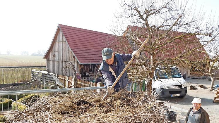 Karl Vollandt aus Steppach reinigt das Nest und richtet  es anschließend mit Segge-Gras gemütlich ein.  Rechts im Bild Heinershof-Hausmeister Alfred Hahn.