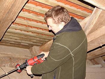 Dendrologe Georg Brütting entnimmt Proben aus dem Gebälk der Kreuzbergkirche. Fotos: Erlwein