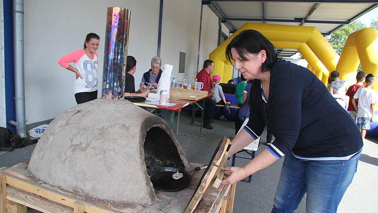 Uschi Prawitz vom Mupäz heizte zum Jubiläumsfestival den selbstgebauten Lehmofen an. Foto: Sonja Adam