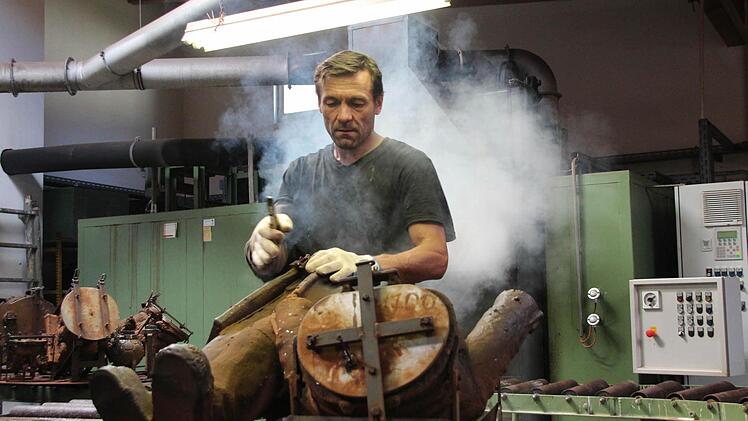 Heißer Arbeitsplatz: Igor Chramov muss die heißen Metallformen mit dem gehärteten Plastik aus dem 290 Grad heißen Ofen schnell abkühlen, bevor er sie herausholen und weiterverarbeiten kann - da dampft es ordentlich.  Fotos: Thomas Heuchling