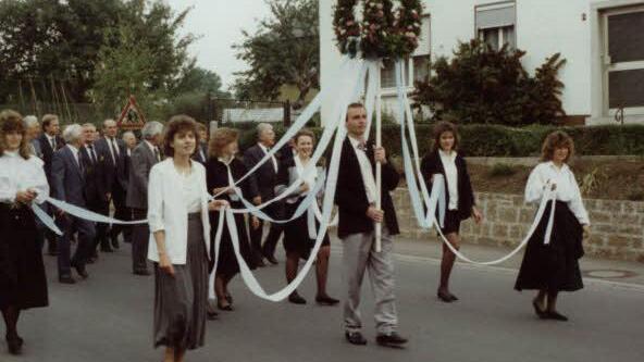 1989 trug der heutige Kreisobmann, Manfred Greubel, bei einem Festzug die Ehrenkrone. Begleitet wurde er von den Ehrendamen.