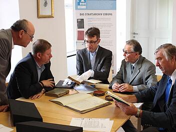 Johannes Haslauer (Mitte) gibt Hans-Karl Bauer, Kreishandwerksmeister Jens Beland, Hugo Thauer und Innungsobermeister Hugo Schamberger (von links) Erläuterungen zu den historischen Büchern. Foto: Ulrike Nauer