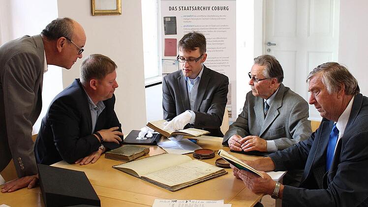Johannes Haslauer (Mitte) gibt Hans-Karl Bauer, Kreishandwerksmeister Jens Beland, Hugo Thauer und Innungsobermeister Hugo Schamberger (von links) Erläuterungen zu den historischen Büchern. Foto: Ulrike Nauer