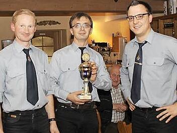 Michael Batz (Mitte) überreicht den goldenen Pokal an Georg Ott (links) und Markus Heilmann. Foto: Carmen Schwind