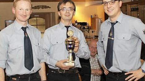 Michael Batz (Mitte) überreicht den goldenen Pokal an Georg Ott (links) und Markus Heilmann. Foto: Carmen Schwind