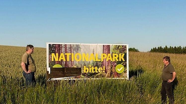 Erst beschmiert, dann zerstört: Das Plakat des Nationalpark-Frankenwald-Befürworters Josef Schedel konnten Gegner nicht so stehen lassen. Das "Ja" wurde herausgeschnitten. Der Widerstand wird radikaler. Entsetzt betrachten die beiden Greenpeace- und Grünen-Aktiven Josef Schedel (links) und Klaus Knorr die Tat.  Foto: Rainer Glissnik
