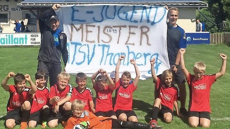 Kräftig feierten die E-Junioren des ATSV Thonberg ihre Meisterschaft. Mit im Bild die beiden Erfolgstrainer Tilo Degenbeck (links) und Marco Mäder.  Foto: ATSV Thonberg