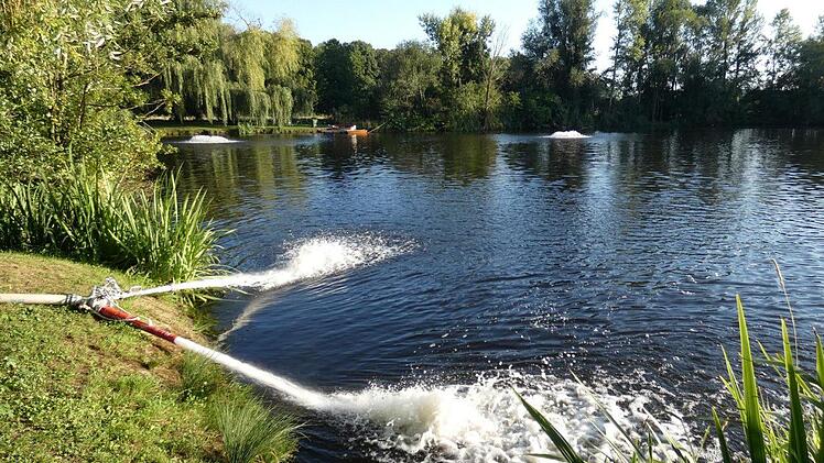 Die Sportangler stellten  einige Sprudelpilze  auf (hinten). Im Vordergrund sorgt die Feuerwehr dafür, dass  Wasser ins "Löchle" gepumpt wird.  Foto: Christian Licha