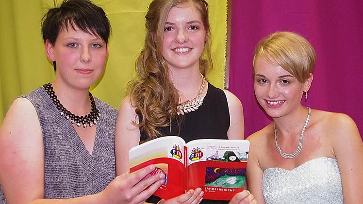 Die Einser-Absolventinnen (von links) Elena Müller, Selina Schuberth und Lena Weiß werfen einen Blick in den Jahresbericht der RS II.