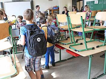 Stühle hoch! Schüler einer vierten Klasse verabschieden sich an ihrem letzten Schultag vor den Sommerferien von ihrem Klassenlehrer. Alle Schüler gehen weg und besuchen verschiedene weiterführende Schulen.   Foto: Christian Charisius/dpa