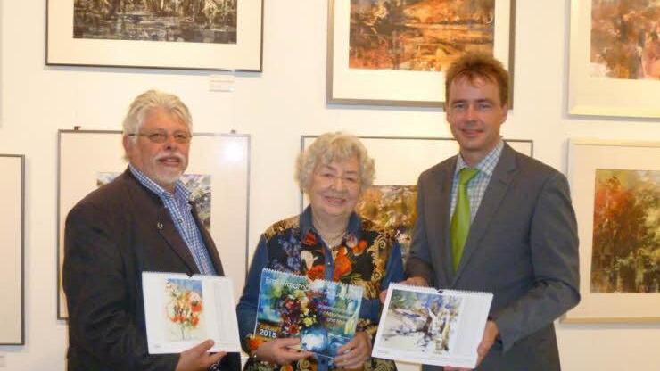 Sie präsentieren den Aquarell-Kalender 2015 nach Blättern von Emil Waldmann: Gabriele Waldmann, Bürgermeister Wolfgang Back (links) und Kurdirektor Thomas Beck..Foto: privat