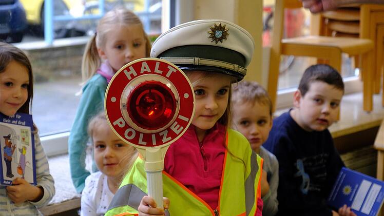 Bevor es zur Exkursion nach draußen ging, durften die Kids noch schnell in Warnjacken schlüpfen. Emilia durfte sich sogar die Polizeimütze aufsetzen und die Kelle halten.