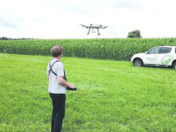 Ein Mitarbeiter des Maschinenrings steuert eine Drohne mit Kapseln zur biologischen Schädlingsbekämpfung über ein Maisfeld. Foto: Maschinenring