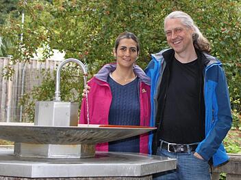 Erinnerungen an früher: Jürgen Neubauer steht  mit seiner Frau Lourdes De Villa am Siebener. Gegenüber des Parks betrieb Neubauers Großvater Ludwig Wolf einst eine Pension mit einer Kneipe. Foto: Ulrike Müller