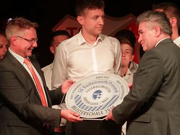 Bei der Meister- und Aufstiegsfeier im Sportheim überreichten die Bürgermeister Stefan Pöhlmann (links) und Siegfried Beyer (rechts) die Meisterschale. Foto: Klaus Klaschka