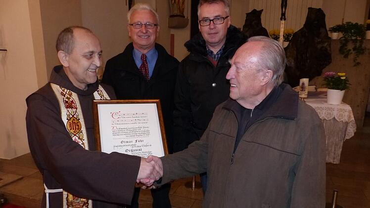 in Würdigung seiner 70-jährigen Tätigkeit als Organist  zeichnete Pfarrer Godfryd Mizerski (links)  Otmar Föhr mit einer  Dankurkunde des Bamberger Erzbischofs Ludwig Schick aus.  Mit im Bild   Kirchenpfleger Robert Göcking (Zweiter von links) und Pfarrgemeinderatsvorsitzender Stephan Melzer. Foto: Klaus-Peter Wulf