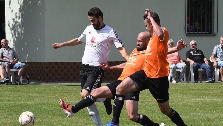 Gegen Steinachs Spielertrainer Michael Voll (links) setzt Wollbachs Matthias Albert, assistiert von Fabian Höper, die Grätsche an. Foto: Hopf