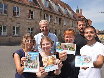 Die Ferienmacher präsentieren vor dem Generationenzentrum in der Erlanger Straße, dem früheren Freizeitheim, die vier Hefte: Evi Bauer, Simone Voit, Bea Wirth und Daniel Birk (vorne von links) mit German Hacker und Thomas Schönfelder (hinten) Foto: Bernhard Panzer