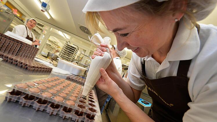 Irene Odenbach von der Confiserie Storath in Stübig (Landkreis Bamberg) befüllt Pralinenförmchen. Bei den fränkischen Nahrungsmittelhandwerkern liefen die Geschäfte zuletzt glänzend. Und vor Weihnachten gibt es nochmals einen Schub. Foto: Ronald Rinklef