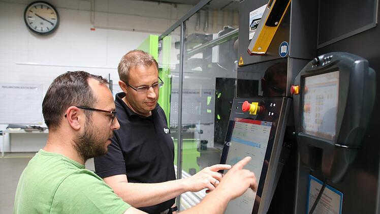 Geschäftsführer Timo Albert (rechts) mit Sebastian Sens an der neuesten, computergesteuerten Spritzguss-Maschine.Ralf Ruppert