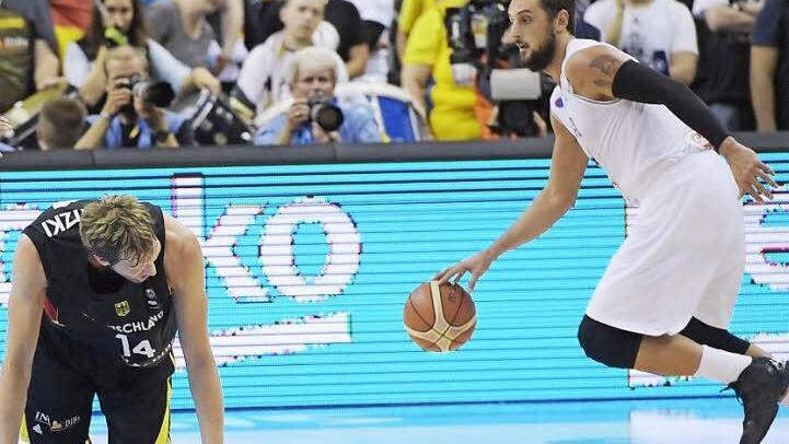 Deutschland am Boden: Dirk Nowitzki kniet, während Italiens Marco Belinelli (rechts) den Ball nach vorne dribbelt und wenig später den entscheidenden Korb erzielt.  Foto: Rainer Jensen/dpa