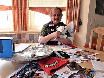 Georg St&ouml;ckel mit einem "Berg" voller Souvenirs von den Olympischen Spielen in S&uuml;dkorea und einer Besonderheit, der gemeinsamen Fahne von S&uuml;d- und Nordkorea.Werner Rei&szlig;aus