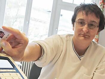 Alltag, der bald der Vergangenheit angehören wird:  Arzthelferin Manuela Closmann prüft, ob  die Patientin  schon die Praxisgebühr bezahlt hat. Zum 1. Januar wird die Gebühr abgeschafft. Foto:  Vanessa Schneider