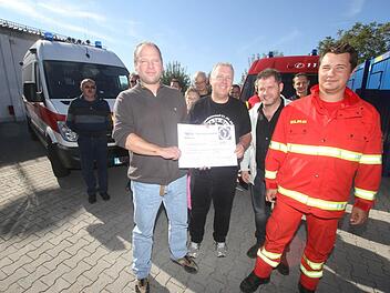 Übergabe der Spende an den Vorstand der Feuerwehr. Fotos: Michael Busch